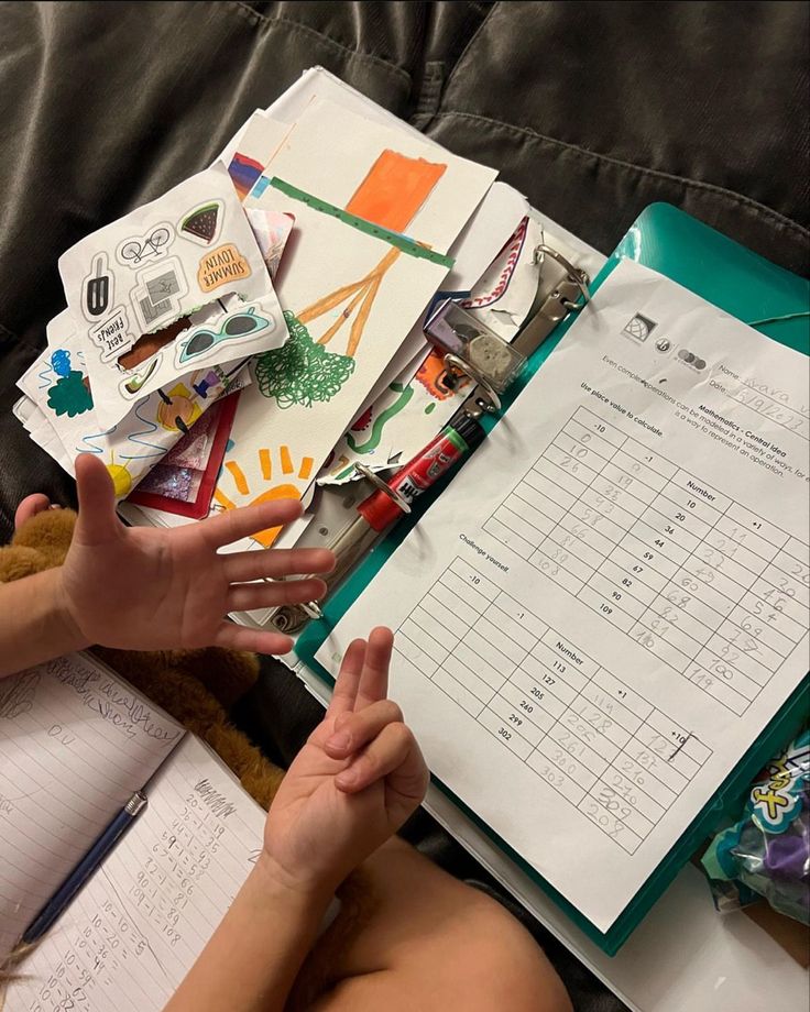 Table covered with worksheets, scissors and craft materials